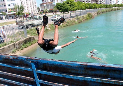Adana'da termometreler 42 dereceyi gösterdi! Tehlikeye rağmen sulama kanalına girdiler